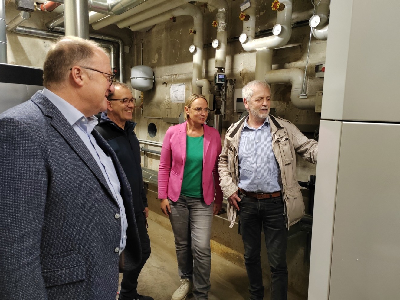 Im Rahmen eines Ortstermins in der Grundschule Wershofen erklärt Herr Pertz vom Ingenieurbüro Pertz (re.) die neue Pelletheizungsanlage. Die Anlage ersetzt die bisherige Ölheizung und trägt durch eine deutliche Reduzierung des CO₂-Ausstoßes zur nachhaltigen Verbesserung der Energieeffizienz der Schule bei. Die Erläuterungen richten sich an Bürgermeister Guido Nisius (li.), Hausmeister Guido Theisen (2. v. li.) sowie Schulleiterin Katja Seibel (2. v. re.).