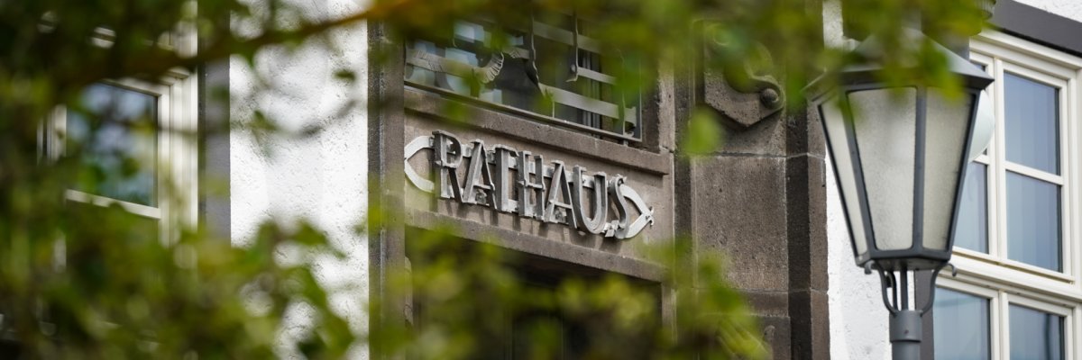 Rathaus hinter grünem Blattwerk Digitale Bürgerservices