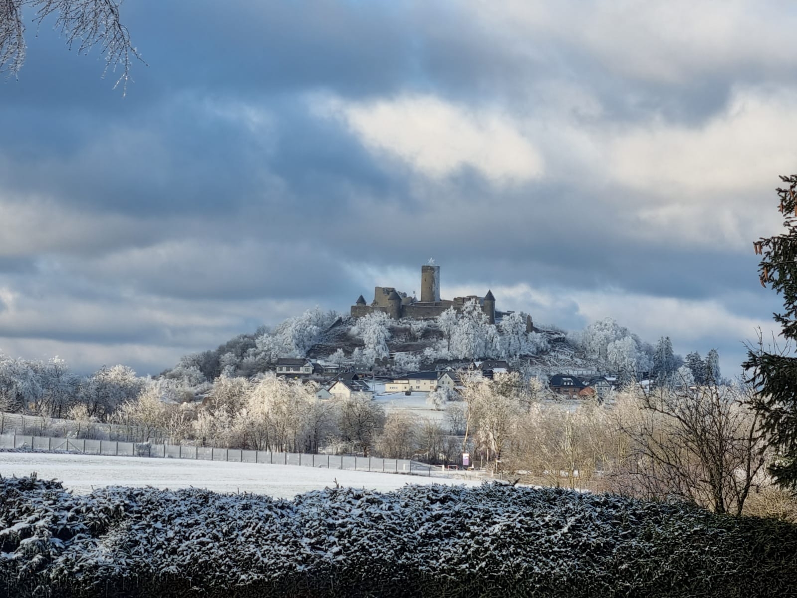 im Hintergrund ist die Burgruine Nürburg mit Winter mit Schnee