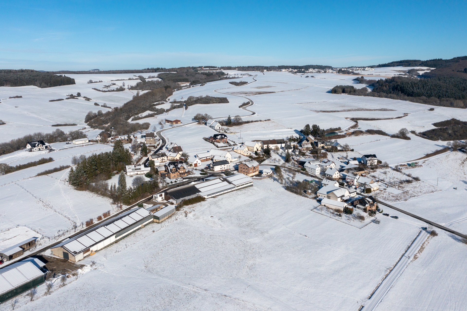 der Ort Bauler aus der Vogelperspektive die Landschaft ist Schneebedeckt rechts und links Waldabschnitte in der Mitte die Häuser